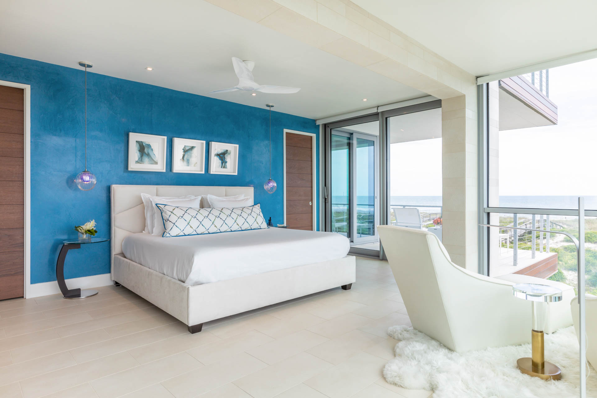 Studio M's award-winning Amelia Island interior design transforms the narrow Fernandina Beach lot into a luxurious three-story coastal home with modern aesthetics, custom blue accents, and innovative space utilization.