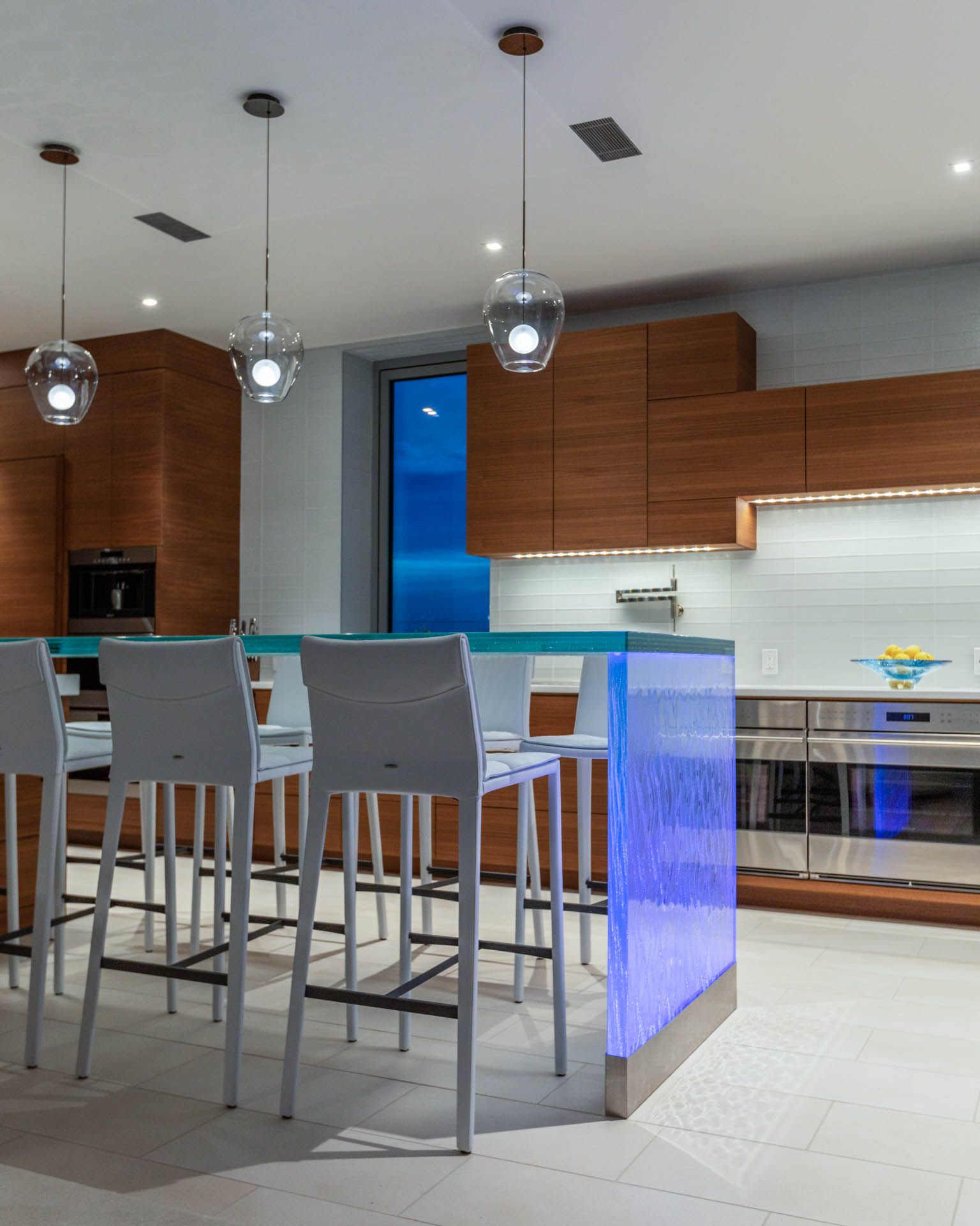 Studio M's award-winning interior design transforms narrow Fernandina Beach lot into luxurious three-story coastal home with modern aesthetics, custom blue accents, and innovative space utilization